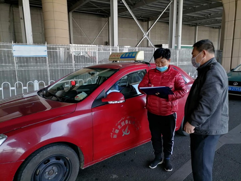 图为：运输公司管理人员在高铁站检查所属出租车处在消毒情况_副本.jpg