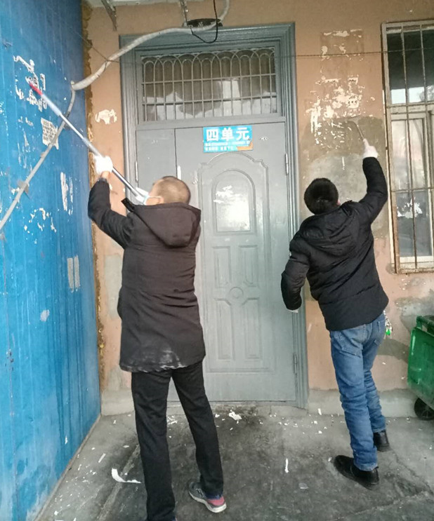 图为：物业公司员工清理小广告现场_副本.jpg